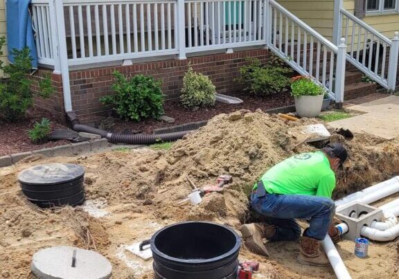 An expert technician works on septic system repairs for a residential septic system in Clayton, NC.